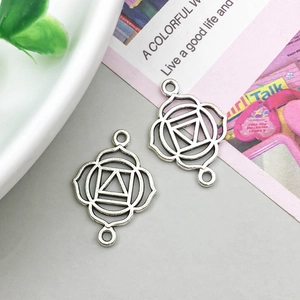 Dettaglio di ciondoli mandala chakra fiore della vita in argento vintage su grigio