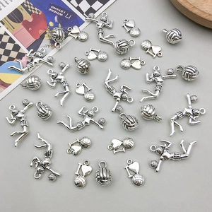 Detailed view of silver antique volleyball player pendants and heart charms for DIY jewelry
