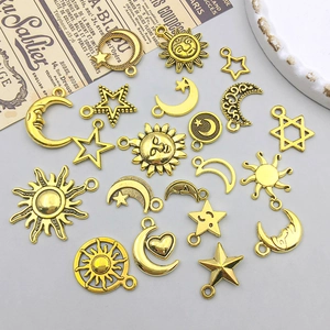 Flat lay of celestial gold alloy charms featuring sun, moon, and star designs for DIY jewelry