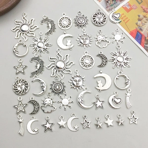 Macro shot of antique silver sun moon and star charms with detailed vintage texture