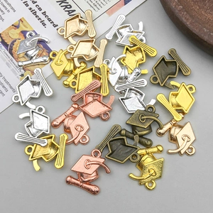 Detailed close-up of alloy graduation cap charms in gold, silver, and bronze finishes