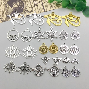 Flachbild von Vintage-Silber- und Gold-Augenanhängern mit rustikalem Papierdetail