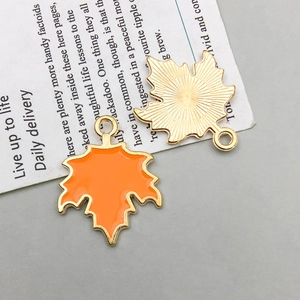 Detail von Ahornblatt-Anhängern mit orangefarbener Emaille und goldener Rückseite