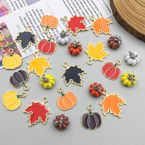 Draufsicht auf bunte Emaille-Ahornblätter und Kürbis-Anhänger für DIY-Schmuck