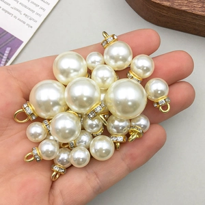 Goldener KC-Legierungsanhänger mit Perlen und Strasssteinen in der Hand für DIY-Schmuck