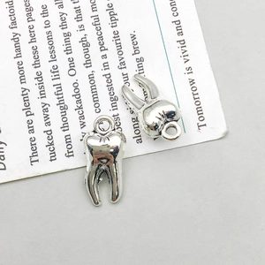 Detailed view of silver alloy molar tooth charms with rings for creative DIY jewelry making