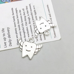 Detail of vintage silver winged tooth charms with smile engravings for DIY jewelry making