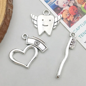Antique silver ambulance and dental charms set with toothbrush and winged tooth design