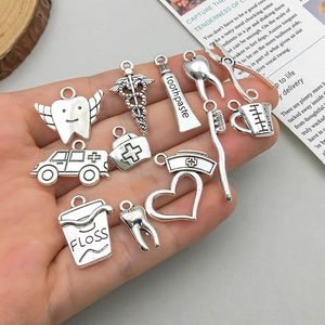 Set of antique silver dental and medical charms including ambulance and tooth pendants