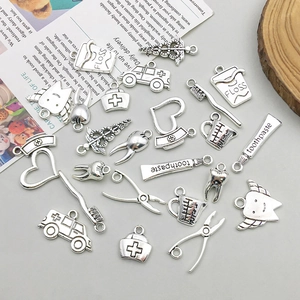 Detailed view of silver antique alloy dental and ambulance charms for DIY jewelry making