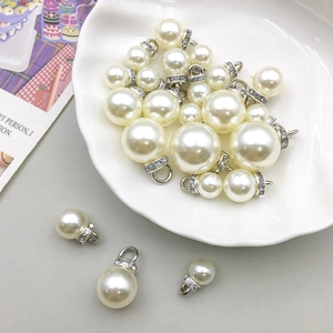 Pendentifs perles blanches avec calottes strass argentés sur coupelle coquille