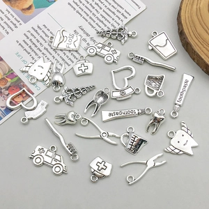 Detailed flat lay of silver alloy medical and dental charms for DIY jewelry making