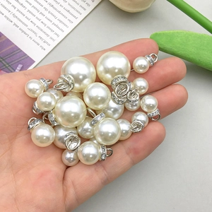 Gros plan de pendentifs en perles avec strass dans une main pour bijoux faits maison