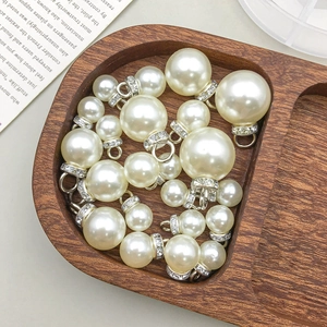 Vue macro de breloques en perles blanches avec des attaches en argent serties de strass