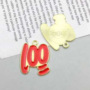 Detail view of red and gold alloy number 100 pendant with textured metal back