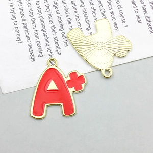 Macro detail of red enamel A+ grade alloy charm pendant with golden electroplated finish