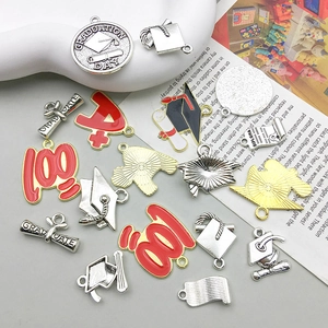 Macro detail of graduation DIY charms set with diploma, cap and red enamel A+ grade logo