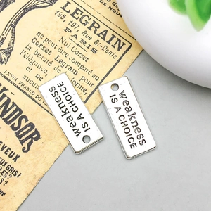 Detalle de dijes rectangulares plateados con grabado weakness IS A CHOICE para joyería DIY