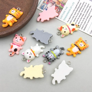 Dettaglio di ciondoli a forma di gatto in resina colorata con ganci per gioielli DIY