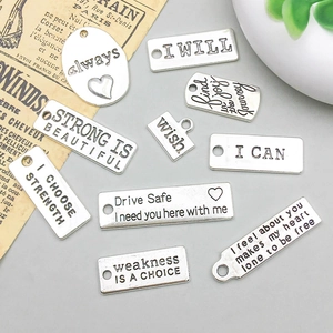 Vista macro de dijes de plata vintage con frases motivacionales grabadas
