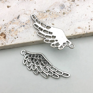 Detail of silver wing pendants showing feather textures and hollow back for DIY jewelry