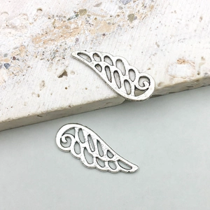 Detailed close-up of antique silver wing charms with intricate filigree texture for DIY jewelry