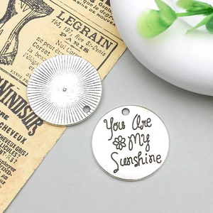Dettaglio di ciondoli You Are My Sunshine incisi in argento per gioielli fai da te