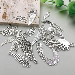Macro shot of antique silver wing charms with floral textures for DIY jewelry crafting