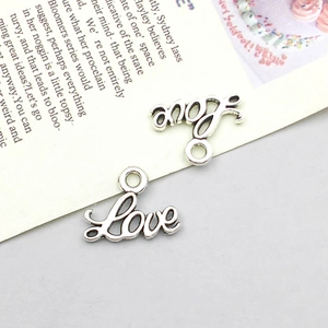 Detailaufnahme von Love-Herzanhängern in Altsilber-Optik für DIY-Schmuck und Halsketten