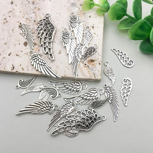 Detailed close-up of antique silver alloy wing charms with intricate feather textures for DIY