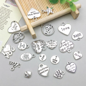 Nahaufnahme von Herzanhängern aus Silberlegierung für DIY-Schmuck mit Vintage Gravur