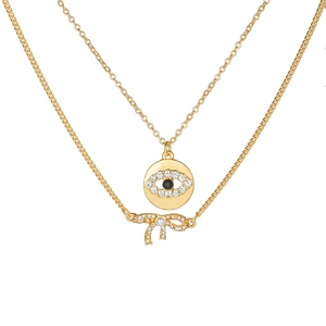 Détail du collier mauvais œil doré avec pendentifs nœud en cristal et perle