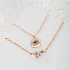 Parure de collier œil maléfique et bracelet nœud dorés avec cristaux et perles