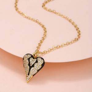 Makroaufnahme vom Herzanhänger mit schwarzer Emaille und Pavé-Zirkonia auf goldener Kette