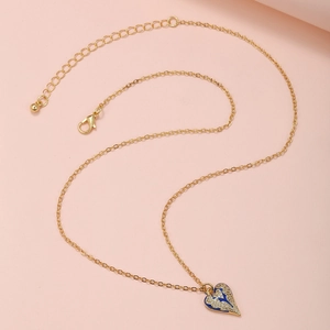 Detailansicht goldener Herzanhänger mit blauer Emaille und funkelnden Zirkoniasteinen