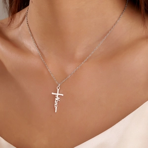 Close-up of a silver stainless steel cross necklace featuring 'Nana' script engraving
