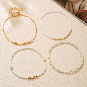Set di bracciali multistrato bohémien in perline oro e bianco con accenti tubolari