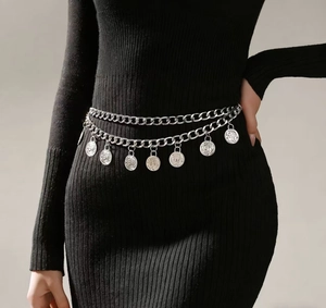 Detail of silver double-layered chain belt with embossed coin pendants on black dress