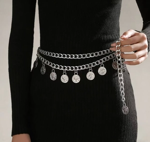 Close-up of vintage silver multi-layer body chain with hanging coin pendants on black dress