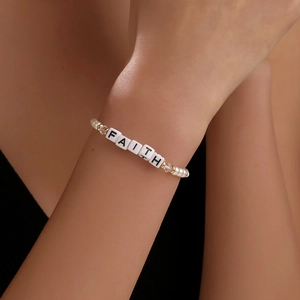 Handgefertigtes Perlenarmband mit FAITH-Buchstaben und Kristallen an einem Handgelenk