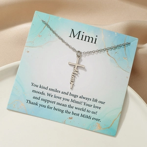 Macro detail of custom Mimi cross necklace on a marble textured gift card