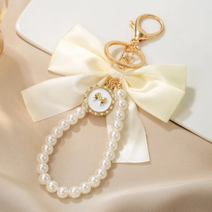 Macro shot of satin bow and luminous pearls with a crystal-encrusted heart charm keychain