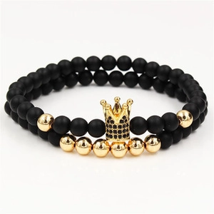 Detailed macro view of 10mm matte volcanic stone beads with a zircon gold crown charm