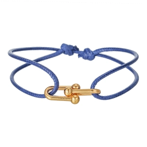 Handmade braided rope couple bracelet with golden U-shaped horseshoe clasp on white background