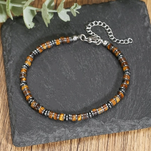Detalle de cuentas de ojo de tigre natural y espaciadores metálicos en pulsera trenzada