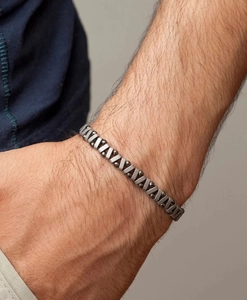 Gedetailleerde opname van een herenarmband van mat metaal met hematiet kralen om de pols