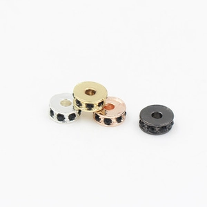 Close-up of alloy spacer beads with black rhinestones in silver, gold and rose gold