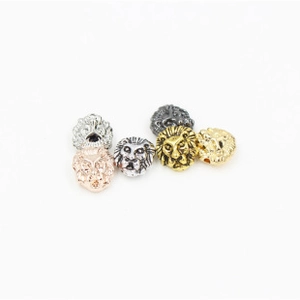 Detailed close-up of lion head metal spacer beads for DIY jewelry making in various colors