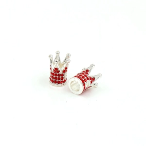 Detailed macro view of silver alloy crown beads with red rhinestones for DIY jewelry making