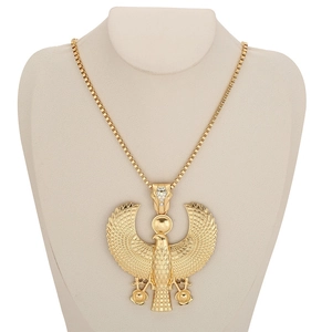 Macro detail of golden Horus Egyptian pendant with wing texture and inlaid diamonds